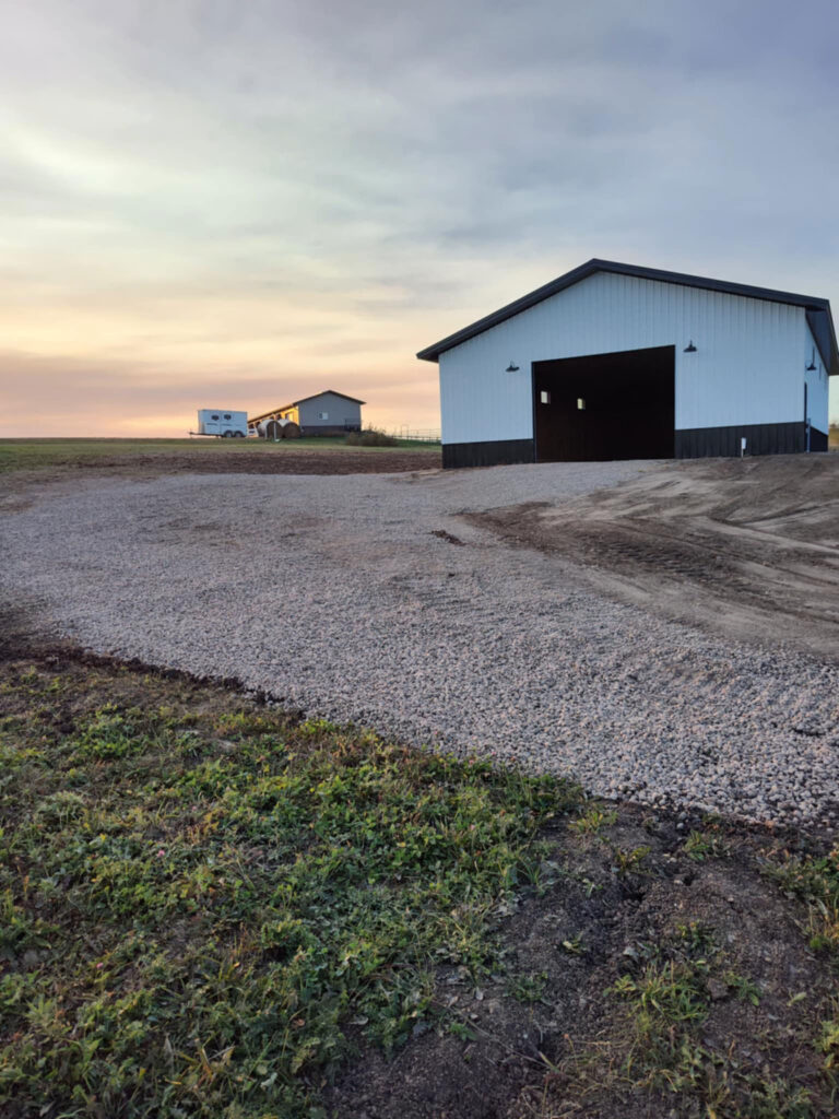 Large shed with a driveway leading to it.