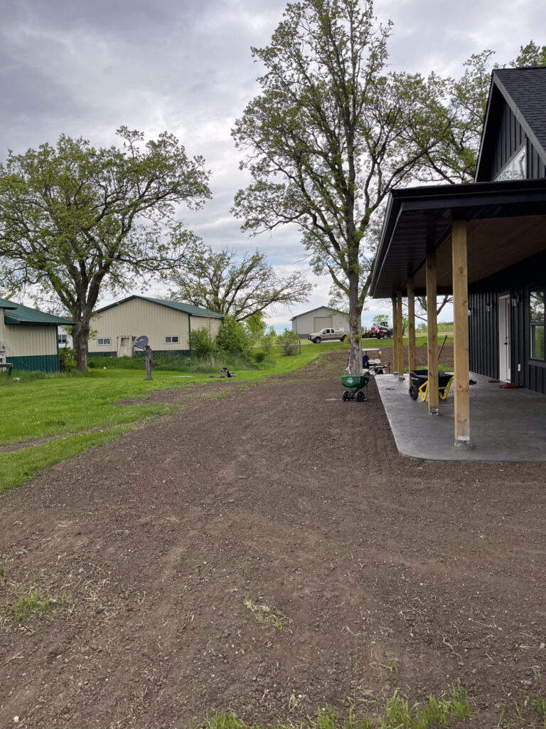Flat land with a shed in the background.