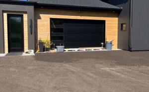 Residential excavation site with freshly graded ground in front of a newly constructed garage.