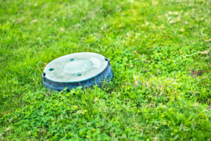 Closeup Of Green Plastic Pipe With Cover On Green Grass Lawn.